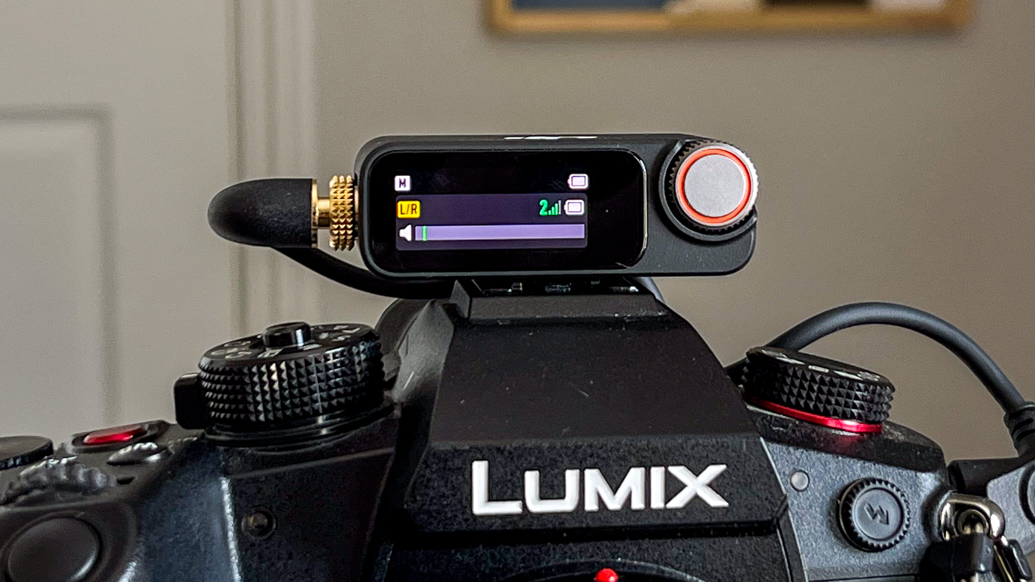 DJI Mic 3 wireless microphone RX unit mounted on top of a Panasonic Lumix mirrorless camera