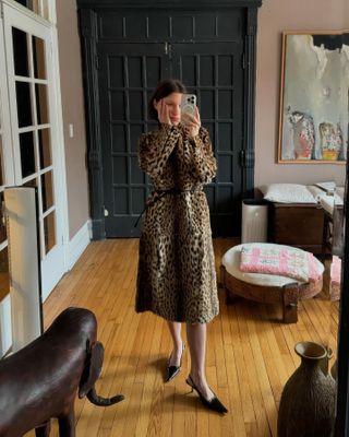 Laura Reilly wearing a leopard print belted coat with black heels.