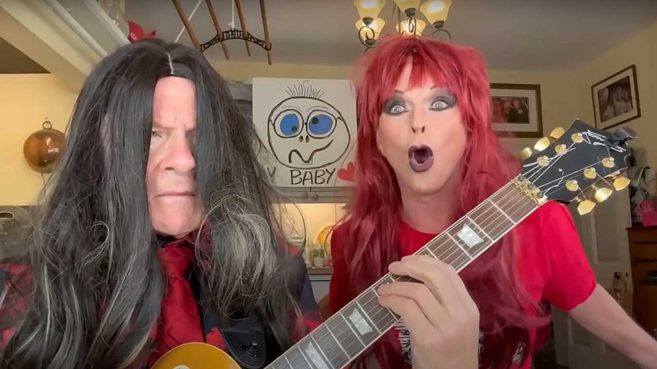 Robert Fripp and Toyah Willcox in their kitchen wearing wigs