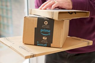 Close up of man holding Amazon prime packages package box home internet shopping delivery