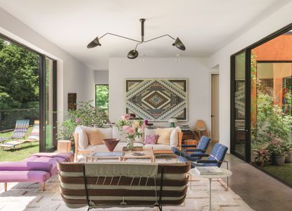 a living room with patterned wall hanging and open patio doors to the outside