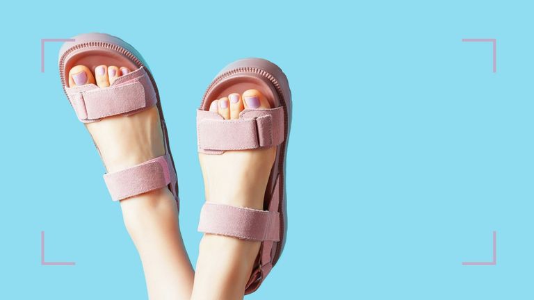 A woman's feet in sandals trying one of this year's biggest pedicure ideas, lilac nails 