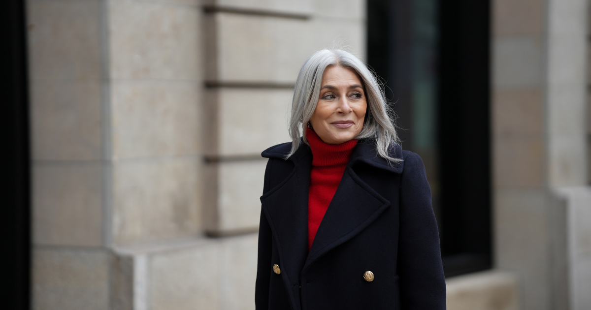 best eyeliner for mature skin Regina Burton is seen wearing a double-breasted navy blue wool coat with gold buttons from Zara; a bright red turtleneck sweater from Victoria Beckham; her silver-grey hair is styled straight and worn loose with a center parting on October 16, 2025 in Hamburg