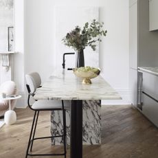 Kitchen with marble table and bouquet of flowers.