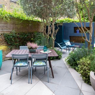 paved area in garden with outdoor table and chairs