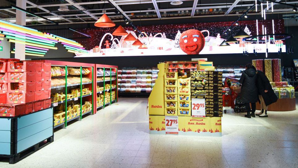 A grocery store lit up by rainbow lights and a massive dvLED PPDS display.