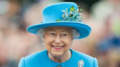 queen smiling in blue hat