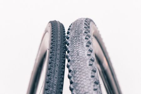 A close up of two tyres, one narrow and one very wide