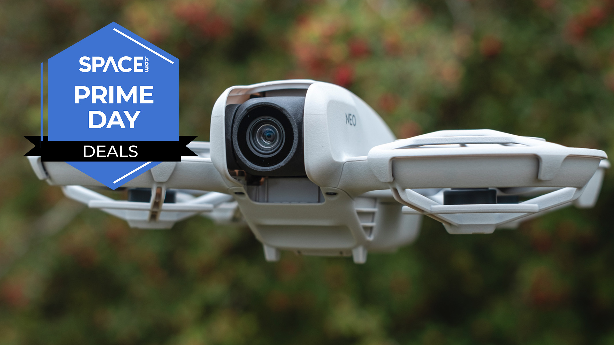 A DJI Neo drone flying in front of a blurred bush or tree. 