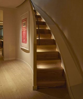 A sweeping staircase with step lighting by John Cullen Lighting