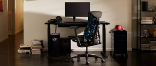 black gaming chair in front of computer desk