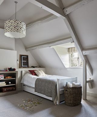 Minimalist small bedroom ideas for kids shown in a white attic room with neutral furnishings, a single bed and dormer window.