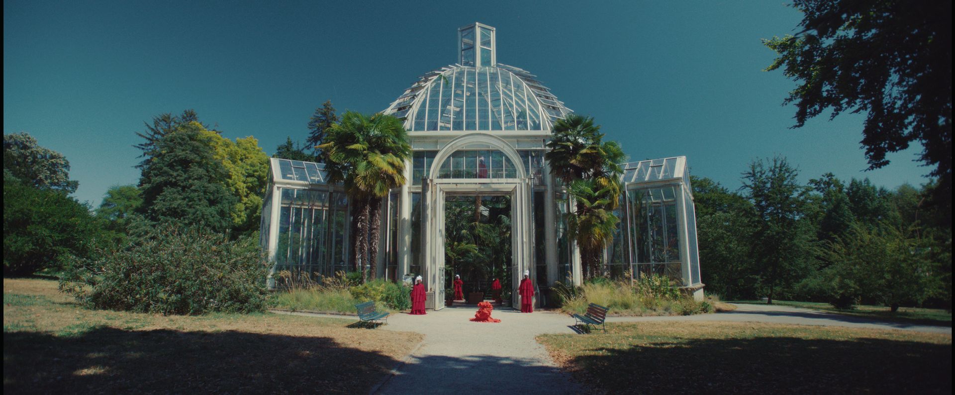 A large, domed glasshouse with women in bright pink outfits