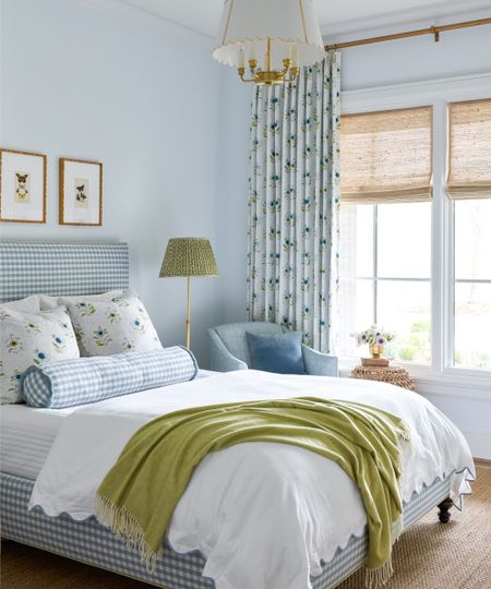 Pale blue bedroom with a green throw and lampsahde by Katie Davis Design