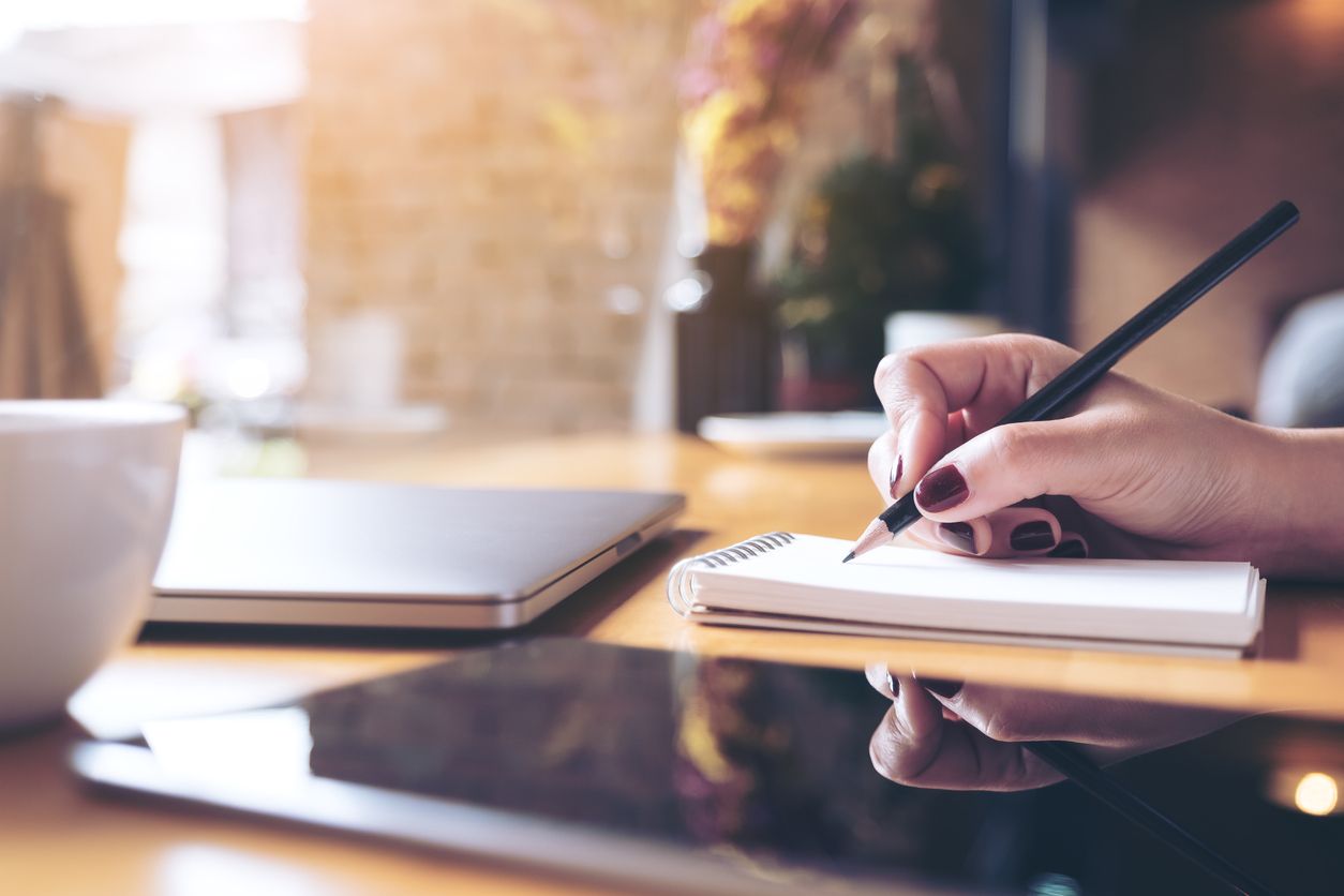 A woman writes in a notepad.