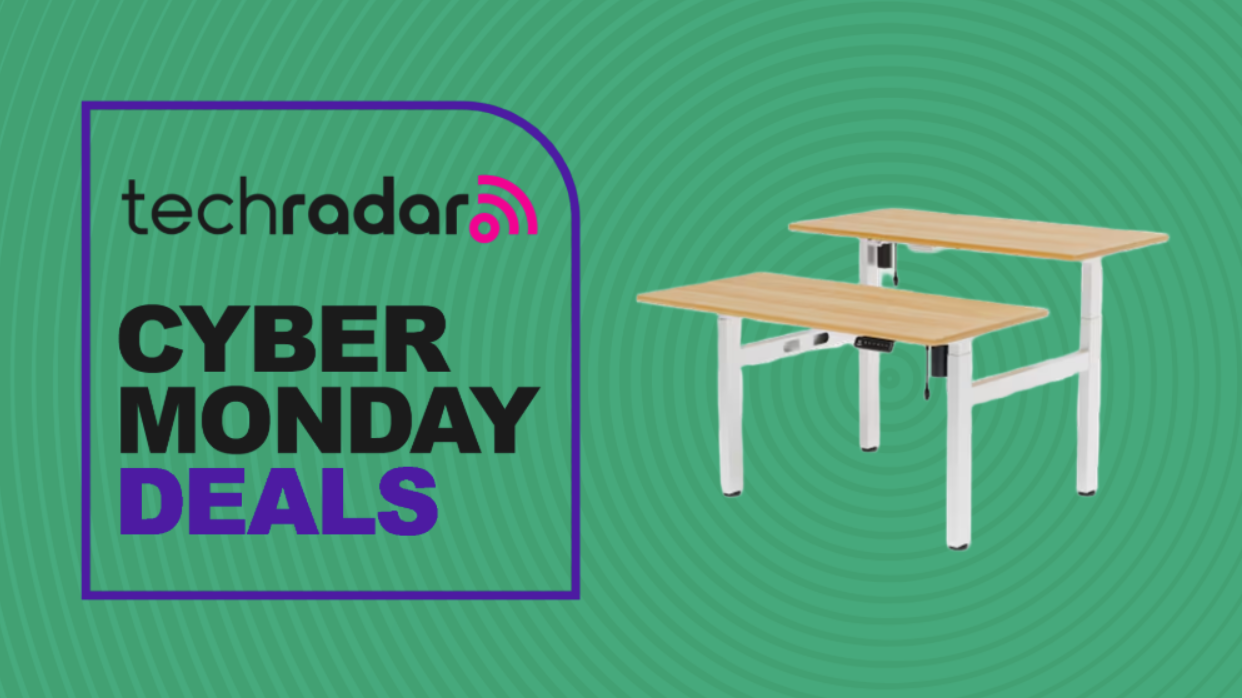 The FlexiSpot EH1 two-person standing desk on a green background next to a TechRadar badge reading 'Cyber Monday deals'