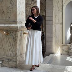 @by_eva_ outfit photo in black v-neck sweater and white midi skirt