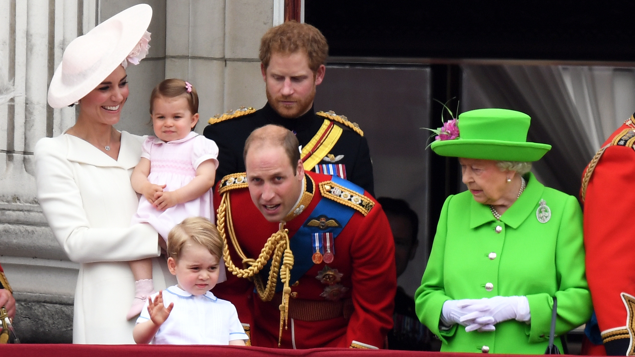 Catherine, Princess of Wales, Princess Charlotte, Prince George, Prince William (bending down), Prince Harry and Queen Elizabeth appear on the balcony of Buckingham Palace at Trooping the Colour 2016