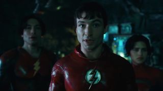 Still from the movie The Flash (2023). Here we see the Flash in costume (but without his mask) with two people either side of him.