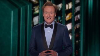 Conan O'Brien smiles as he stands in a blue tuxedo at the 97th Academy Awards.