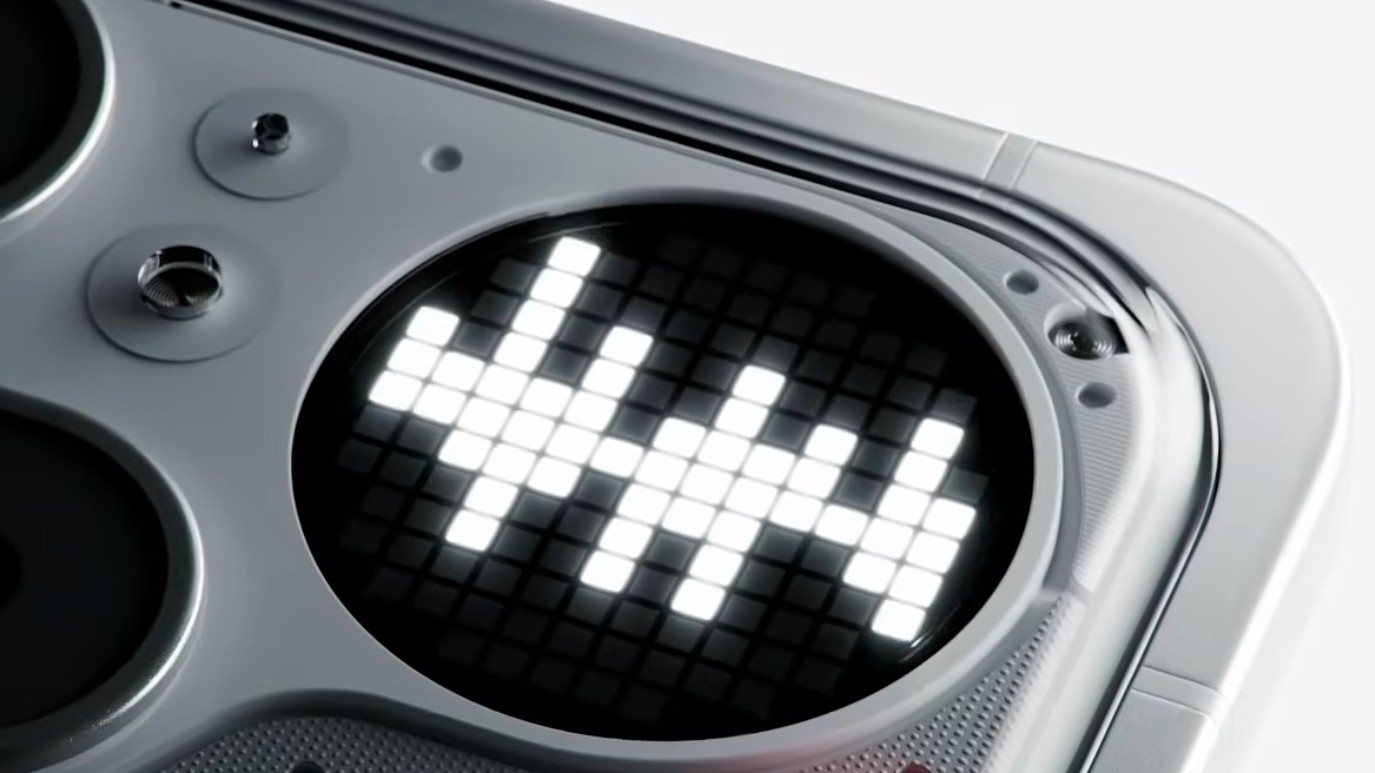 A macro close-up reveals a circular LED pixel display on the back of a device, illuminated with white blocks to form a decorative pattern.