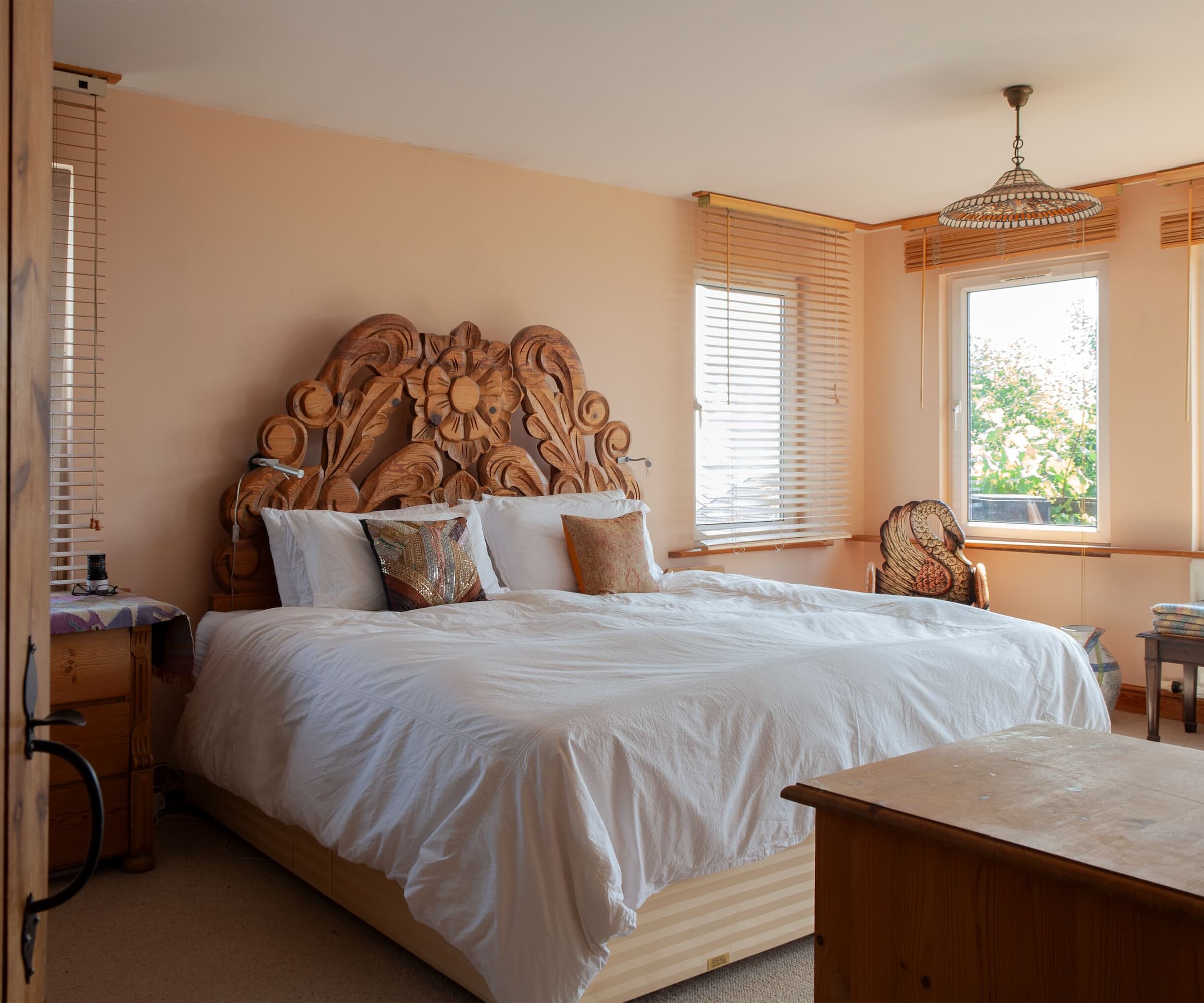 A bedroom with a wooden carved frame