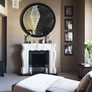 fireplace with round mirror and picture frame