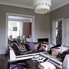 living room with white chandelier and sofa set with cushion