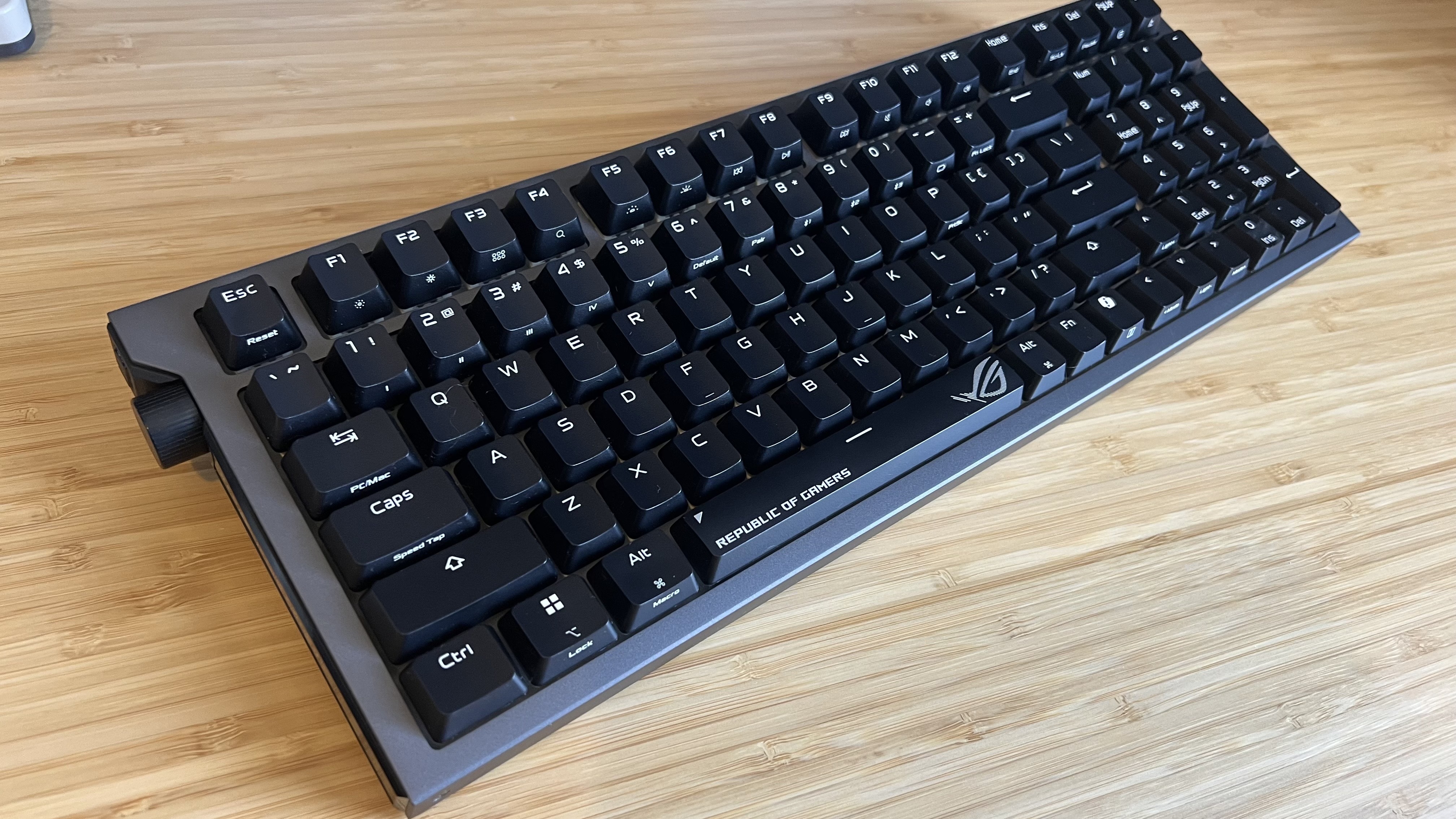 Asus ROG Strix Morph 96 Wireless gaming keyboard on a wooden desk without RGB lighting