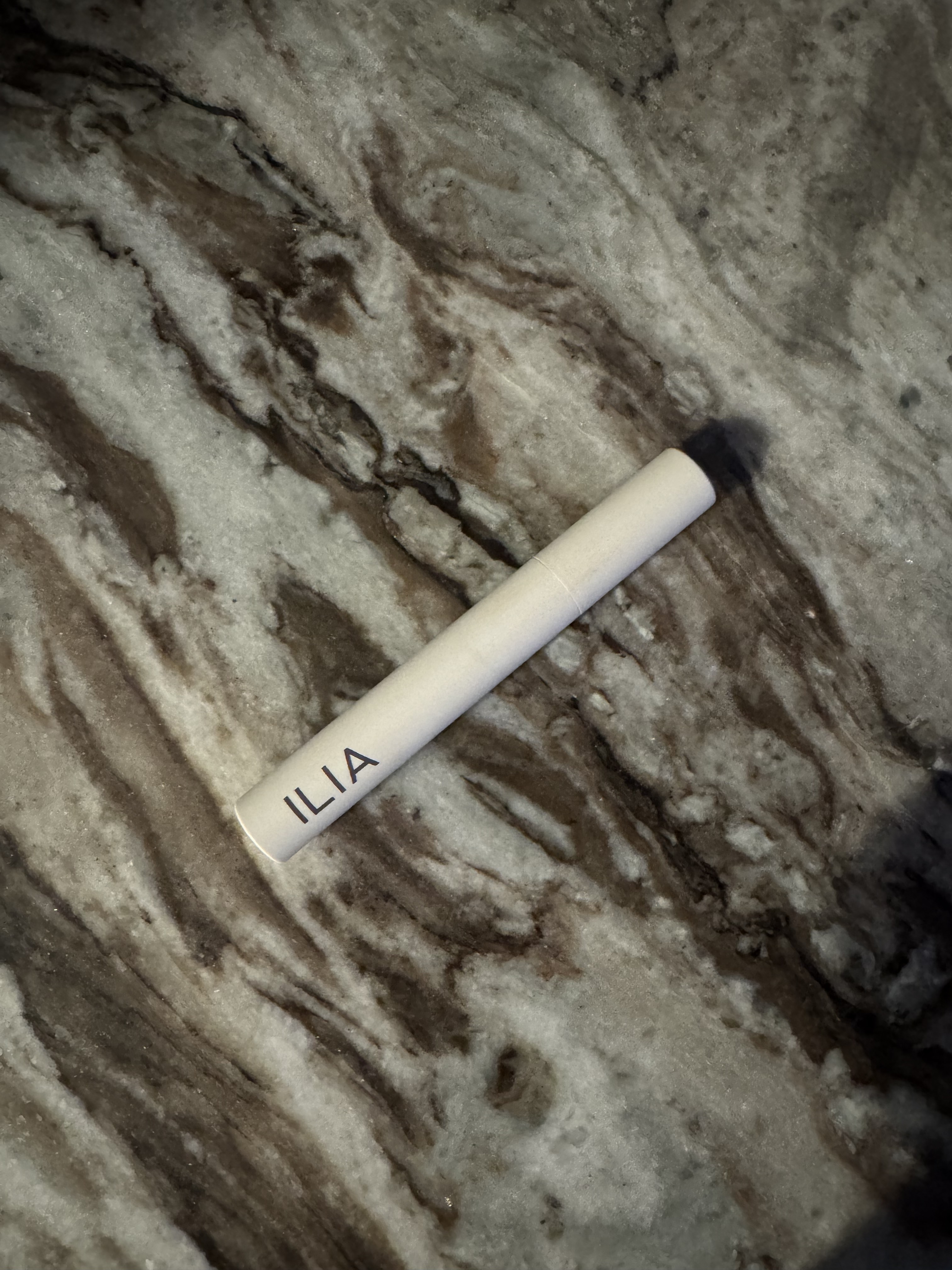 A photo of the Ilia limitless mascara tube on a table