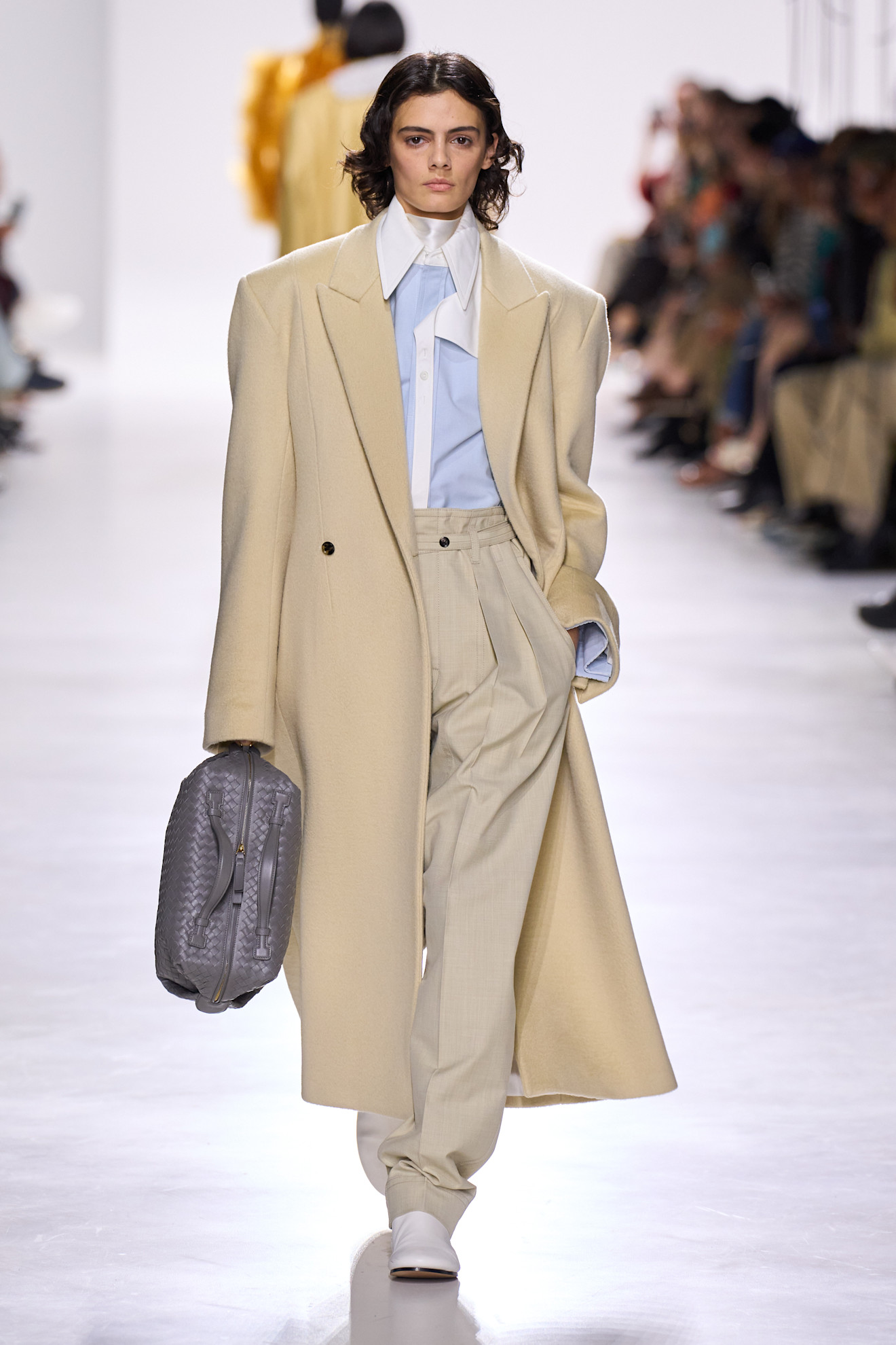An image of a cream coat on Bottega Veneta's autumn/winter 2025 runway.