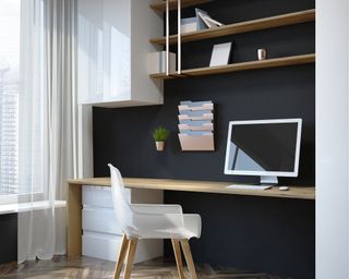 Home office with black wall and white chair