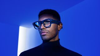 The TCL RayNeo X2 glasses being worn by a person in a blue room