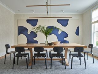 Minimalist dining room with large abstract art on the walls