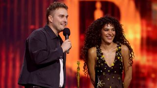 Olivia Dean (R) presents Sam Fender (L) with the 'Song of the year' award on stage during The BRIT Awards 2026 at Co-op Live on February 28, 2026 in Manchester, England.