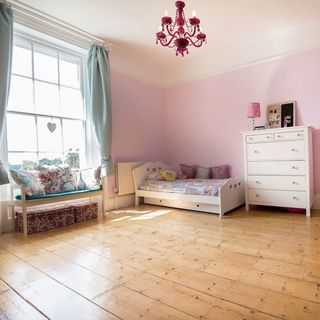 childrens room with pink walls bed and wooden vanity