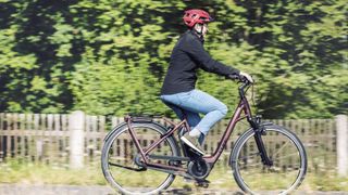 Image shows a person riding a Cube Town Hybrid to reap the benefits of riding an electric bike