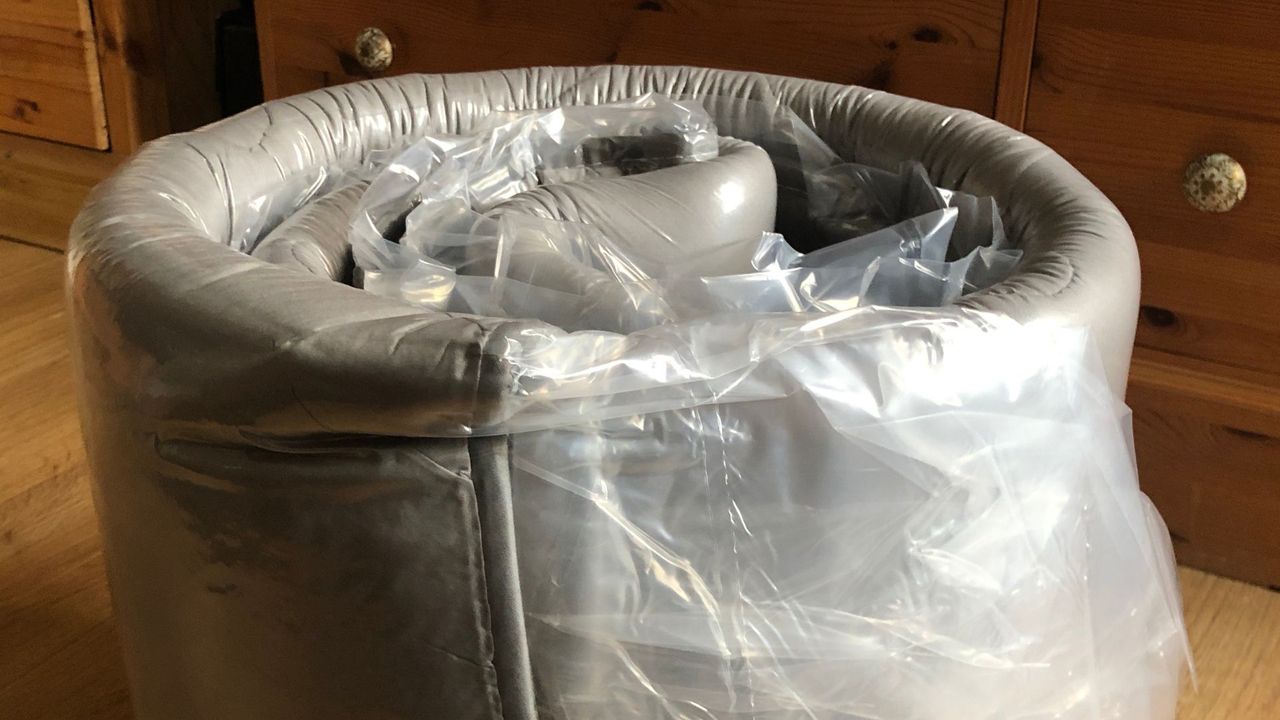 A MAXYOYO Japanese floor mattress rolledup in plastic after being unboxed