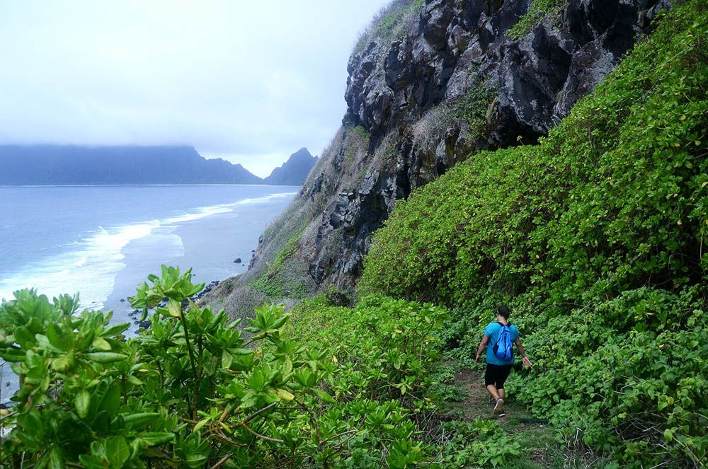 A hiker nears the shore on Ofu&amp;#039;s neighbor isle, Olosega.