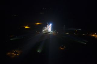 Space shuttle Atlantis lit up on launch pad