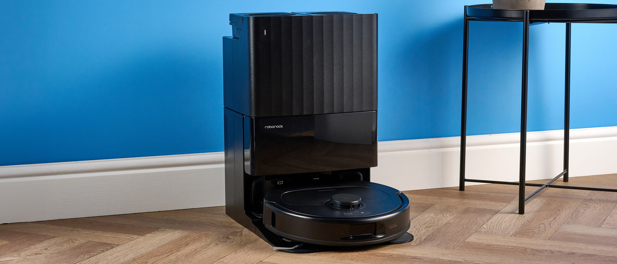 Roborock QV 35S with dock photographed in front of a blue background