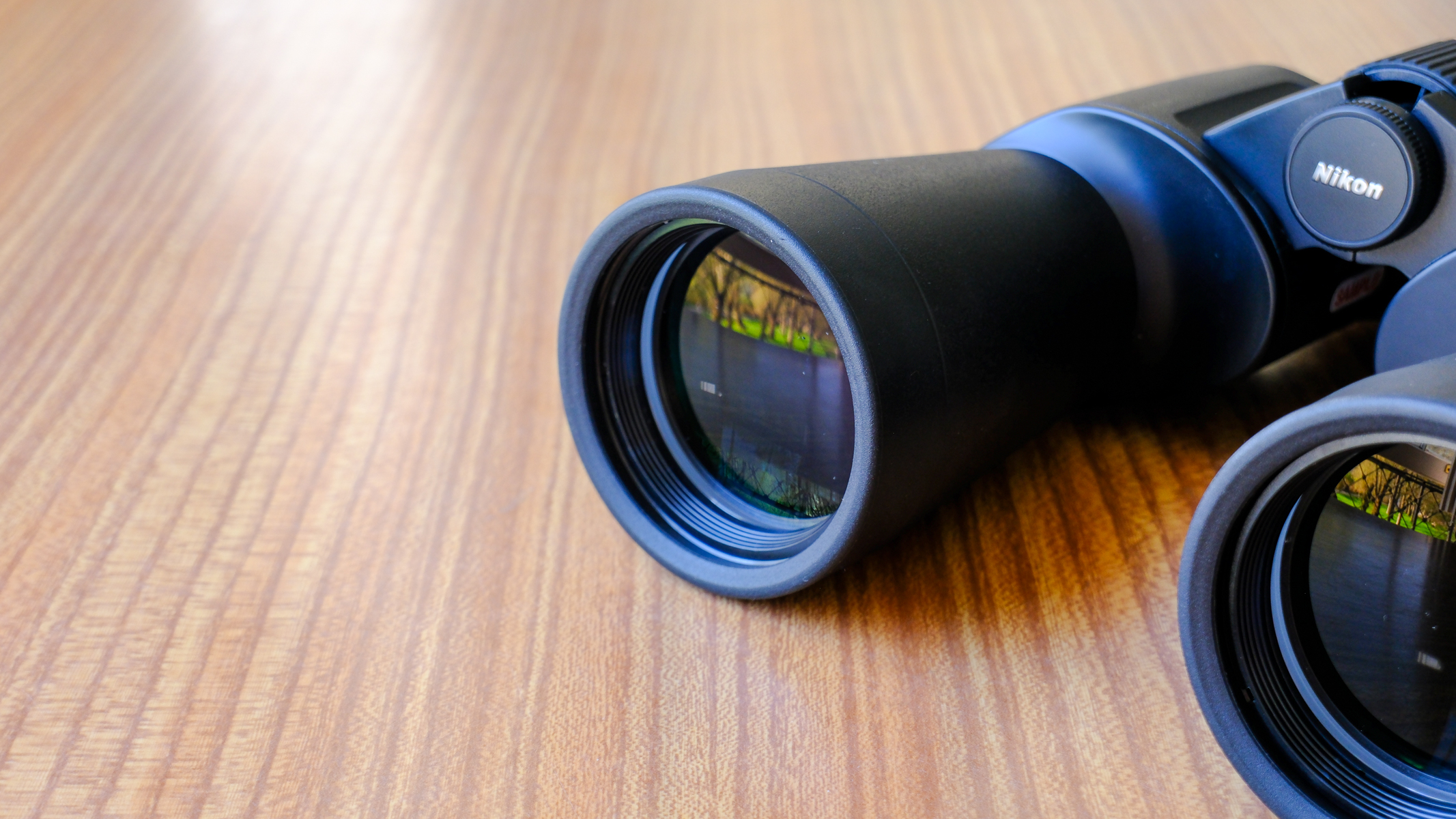 The Nikon Action 7x50 binoculars on a wooden table.