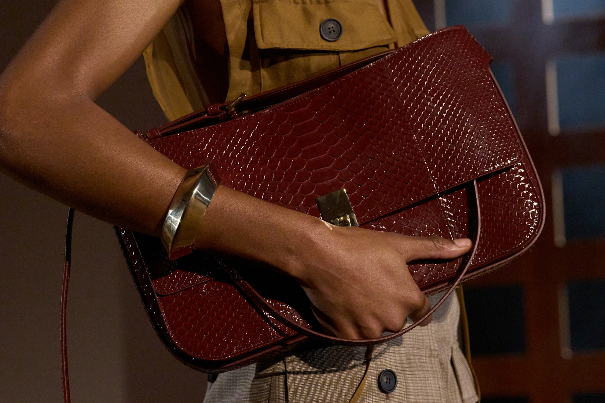 a woman carries a clutch bag at the ferragamo spring 2027 show.