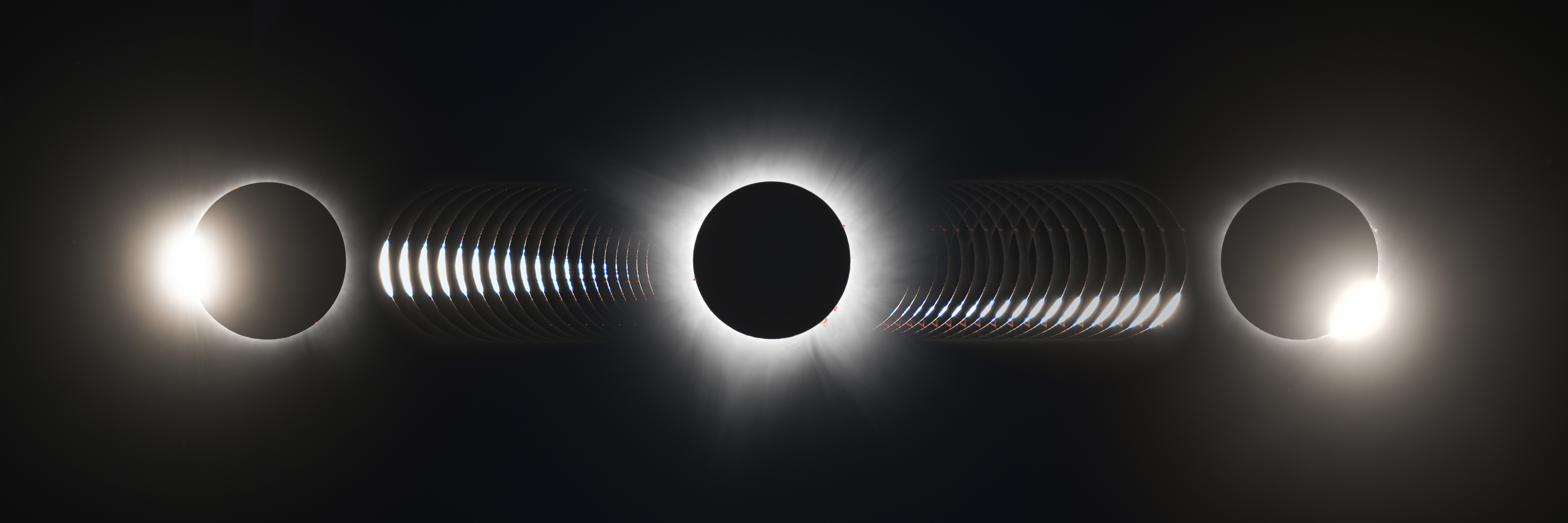 A composite photo of two solar eclipses showing bright lights on opposite sides against a dark background