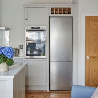 White Kitchen with a white island and silver fridge