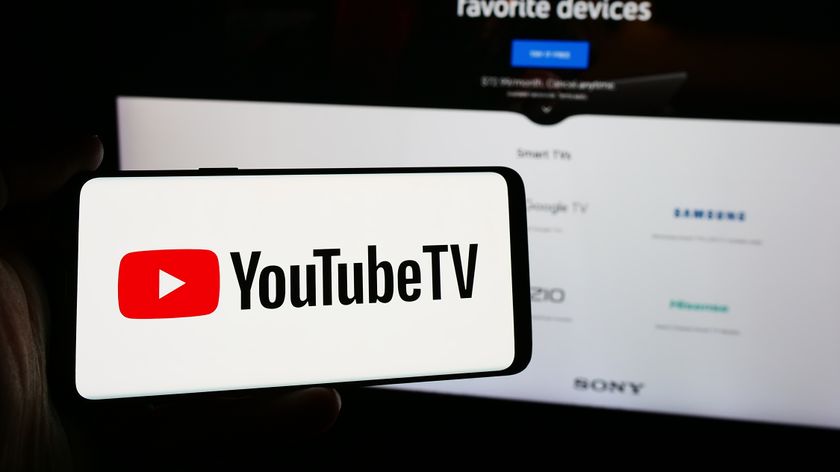Person holding smartphone with logo of US IPTV service YouTube TV in front of website