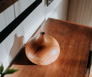 A wooden humidifier turned on on a side board