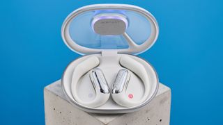 AceFast AceFit Pro open earbuds and the light up charging case photographed in front of a blue background.