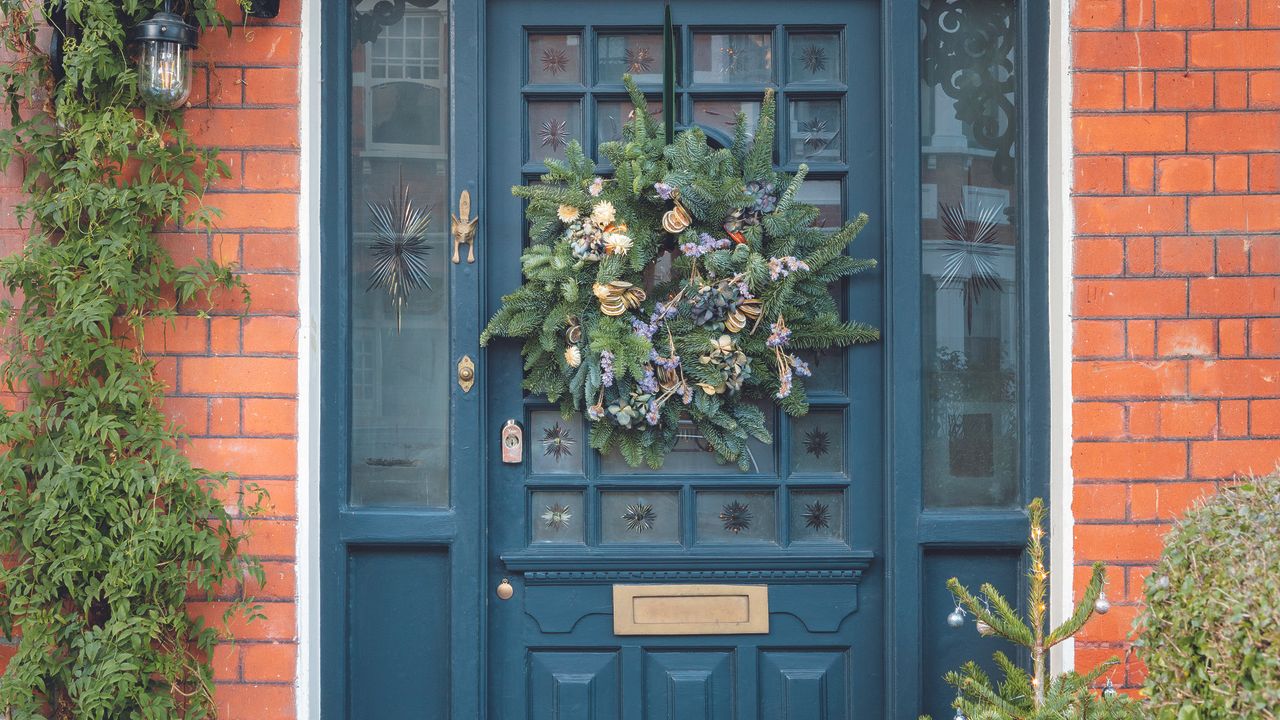 Navy front door with Christmas wreath on the outside.