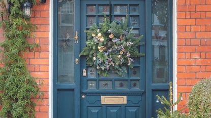 Navy front door with Christmas wreath on the outside.